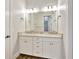 Bathroom featuring double sink vanity, white cabinets, granite countertops, and wood look flooring at 441 N Capen Ave, Winter Park, FL 32789