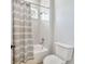 Shower and bathtub combo with gray and white striped curtain and toilet at 441 N Capen Ave, Winter Park, FL 32789