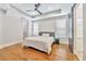 Comfortable bedroom with hardwood floors, a ceiling fan, and a barn door to the en-suite bathroom at 441 N Capen Ave, Winter Park, FL 32789