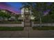 Charming two-story home with manicured front yard and gated entrance at twilight at 441 N Capen Ave, Winter Park, FL 32789
