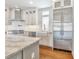Modern kitchen with white cabinets, stainless steel appliances, granite counters, hardwood floors, and island at 441 N Capen Ave, Winter Park, FL 32789
