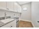 Laundry room featuring ample storage with a mini-fridge and a granite topped sink at 441 N Capen Ave, Winter Park, FL 32789