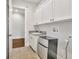 Well lit laundry room with upper cabinets, mini fridge, and granite countertop utility sink at 441 N Capen Ave, Winter Park, FL 32789