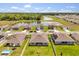 Scenic aerial view shows neighborhood pond, complimented by large surrounding trees, and a view of neighboring houses at 445 Auburn Grove Pl, Auburndale, FL 33823