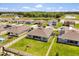 Scenic aerial view shows neighborhood pond, complimented by large surrounding trees, and a view of neighboring houses at 445 Auburn Grove Pl, Auburndale, FL 33823