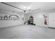 Spacious garage with epoxy flooring, storage shelves, and white door at 445 Auburn Grove Pl, Auburndale, FL 33823