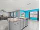 Open-concept kitchen featuring an island with seating, stainless steel appliances, and views of the living room at 445 Auburn Grove Pl, Auburndale, FL 33823