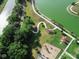 Aerial view of community park with walking path, playground, green space, and serene lake at 459 Dancing Water Dr, Winter Springs, FL 32708