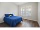 Simple bedroom with a comfortable blue bed, hardwood floors, and a window with white shutters at 459 Dancing Water Dr, Winter Springs, FL 32708