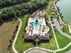 Aerial view of a community pool with sun loungers, palm trees, and a playground nearby at 459 Dancing Water Dr, Winter Springs, FL 32708