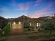 A beautiful dusk shot shows a well-lit single-Gathering home with a dormer, garage and porch at 459 Dancing Water Dr, Winter Springs, FL 32708