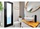 Contemporary bathroom featuring a wood countertop, modern sink, and frosted glass door at 460 Crownclover Ave, Orlando, FL 32828