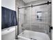 Elegant bathroom features a glass-enclosed shower with sleek tile, a built-in niche and modern fixtures at 460 Crownclover Ave, Orlando, FL 32828