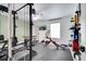 Bright home gym with black rubber flooring, TV and full set of weights and equipment at 460 Crownclover Ave, Orlando, FL 32828