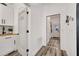 Bright hallway with white walls, wood look floors, and convenient access to laundry at 460 Crownclover Ave, Orlando, FL 32828