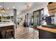 Bright kitchen features gray wood-look floors, stone column, and large sliding doors to the outside at 460 Crownclover Ave, Orlando, FL 32828