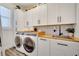 Well-appointed laundry room with white cabinets, wood countertop and stainless steel appliances at 460 Crownclover Ave, Orlando, FL 32828