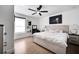 Bright main bedroom features a ceiling fan, large window, moon art, and wood flooring at 460 Crownclover Ave, Orlando, FL 32828