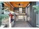 Outdoor kitchen with stainless steel grill, stone countertops, and covered ceiling with fan at 460 Crownclover Ave, Orlando, FL 32828