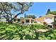 Serene backyard with a patio and a lush lawn shaded by a mature oak tree at 505 S Cooper St, New Smyrna Beach, FL 32169