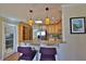 Cozy kitchen featuring a granite countertop bar, wooden cabinetry, and stylish pendant lighting fixtures at 505 S Cooper St, New Smyrna Beach, FL 32169