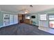Cozy living room features a brick fireplace, built-in shelving, and a ceiling fan at 505 S Cooper St, New Smyrna Beach, FL 32169