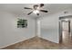 Bright bedroom featuring neutral walls, tile floors, a ceiling fan, and a window offering natural light at 5939 Stokes Rd, Lakeland, FL 33812