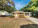 Inviting one-story home with a bright yellow exterior, well-kept landscaping and a white picket fence at 5939 Stokes Rd, Lakeland, FL 33812