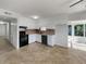 Well-lit kitchen featuring white cabinets, tile backsplash, and black appliances at 5939 Stokes Rd, Lakeland, FL 33812