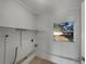 Practical laundry area features a window, storage shelves, and tile flooring at 5939 Stokes Rd, Lakeland, FL 33812