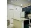 Modern kitchen features an island with granite countertops and stainless-steel appliances at 6863 Tussilago Way, Orlando, FL 32822