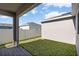 A view of the backyard featuring green grass and a white privacy fence on a sunny day at 779 Firerock Ln, Debary, FL 32713