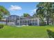 The house with an enclosed pool and well-maintained lawn visible from backyard under a blue sky at 8061 Bangle Ln, Orlando, FL 32836
