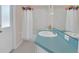 Bright bathroom features a white shower curtain with colorful pom poms and a blue vanity at 8061 Bangle Ln, Orlando, FL 32836