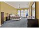 A bright bedroom with a ceiling fan, dresser, large window and carpeted floor at 8061 Bangle Ln, Orlando, FL 32836
