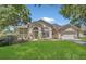 Charming single-Gathering home with well-manicured lawn, arched entry, and a two car garage at 8061 Bangle Ln, Orlando, FL 32836
