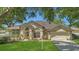 Charming single-story home featuring a well-manicured lawn and mature trees, plus a two-car garage at 8061 Bangle Ln, Orlando, FL 32836