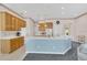 Well-lit kitchen with a blue island, white countertops, wood cabinetry, and modern appliances at 8061 Bangle Ln, Orlando, FL 32836