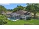 A beautiful aerial view of a screen enclosed swimming pool with well maintained lawn and mature trees at 8061 Bangle Ln, Orlando, FL 32836