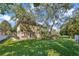 Spacious backyard with mature trees and lush greenery, offering ample space and privacy at 9018 Southern Breeze Dr, Orlando, FL 32836