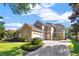 Charming two-story home with a red tile roof, manicured landscaping, and a brick driveway at 9018 Southern Breeze Dr, Orlando, FL 32836