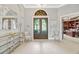 Elegant foyer with tile flooring, decorative mirror and console, chandelier, and view to office at 9018 Southern Breeze Dr, Orlando, FL 32836