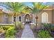 Beautiful home featuring palm trees flanking the front entrance with a brick walkway and lush landscaping at 9018 Southern Breeze Dr, Orlando, FL 32836