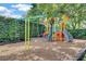 A colorful playground with a swing set surrounded by lush landscaping and mature trees at 9018 Southern Breeze Dr, Orlando, FL 32836