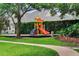 A colorful playground in a community featuring slides, climbing stairs, and mature trees at 9018 Southern Breeze Dr, Orlando, FL 32836