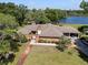 Aerial view of a single-story brick house with a covered carport and lake view at 29 Windsor Isle Dr, Longwood, FL 32779