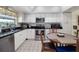 Efficient kitchen boasting white cabinets, black countertops, stainless steel appliances, and tile flooring at 29 Windsor Isle Dr, Longwood, FL 32779