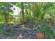 This backyard features a charming water feature, mature landscaping, and brick walkways for an inviting outdoor retreat at 1125 N Mc Donald St, Mount Dora, FL 32757