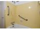 Yellow tiled bathroom featuring a bathtub, shower with grab bars, and a white shower curtain at 1125 N Mc Donald St, Mount Dora, FL 32757
