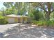 Charming single-story home featuring a brick driveway, attached garage, and mature trees in a lush landscape at 1125 N Mc Donald St, Mount Dora, FL 32757